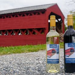 Red bridge in background with Adams County Winery Christmas white and red wine in the foreground.