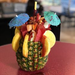 Manny's Shaved Ice N' Snacks - PIÑA LOCA "crazy pineapple ". Mixed fresh fruit inside of pineapple.  With takis, peanuts, chamoy and Tajín.