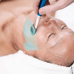 Conscious Skin Care - Brushing on handmade rejuvenating mask as part of the facial treatment.
