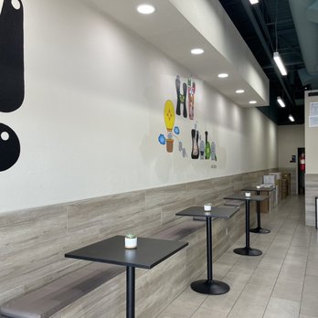 Hi Boba - A clean, well-lit interior of a boba tea shop featuring small tables, benches, and wall art related to drinks. - Coffee & Tea Near Me - Rio Rancho, New Mexico