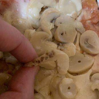 Two Brothers Pizza - a hand picking up a slice of pizza - Pizza Near Me - Bronx, New York