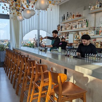 elNico - a bar with stools and a man behind the bar - Mexican Near Me - Brooklyn, New York