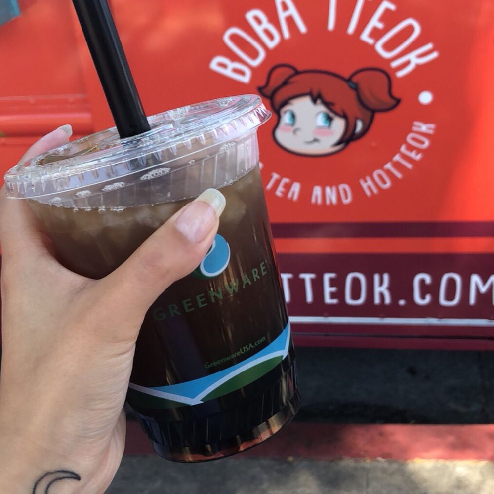 Boba Tteok - a hand holding a cup of coffee - Bubble Tea Near Me Boba Tteok - a hand holding a cup of coffee - Bubble Tea Near Me