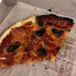 A piece of pizza that is burnt A piece of pizza that is burnt