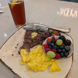 Steak and eggs and berries and unsweet tea with lemon