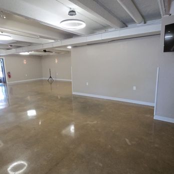 The Vault 106 - A spacious, empty room with polished concrete floors, ceiling lights, and a wall-mounted TV, likely used for events or gatherings. - Venues & Event Spaces Near Me - Aurora, Illinois