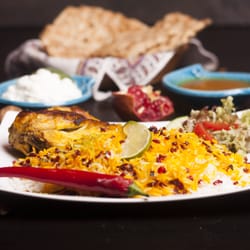 Anar Restaurant - Zereshk polo ba Morgh Unterschenkelkeule gebraten mit edlen Basmatireis und Safranhaube dazu Berberitzen