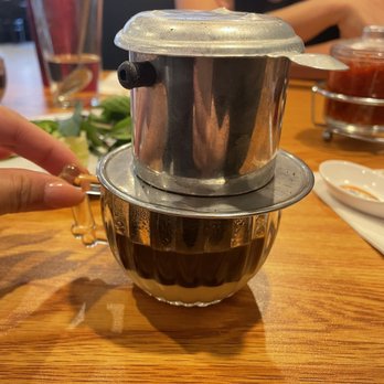 Pho Legacy - a woman's hand reaching for a mixing bowl - Vietnamese Near Me - Irving, Texas