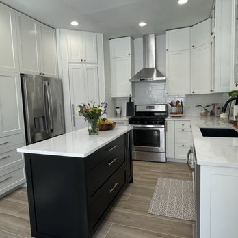 Isla Contractors - a kitchen with white cabinets and black appliances - General Contractors Near Me Isla Contractors - a kitchen with white cabinets and black appliances - General Contractors Near Me