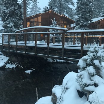 Woodlands On Fall River - Cabin #1 and #2 in the distance. River with bridge entrance to property seen. - Hotels Near Me - Estes Park, Colorado Woodlands On Fall River - Cabin #1 and #2 in the distance. River with bridge entrance to property seen. - Hotels Near Me - Estes Park, Colorado