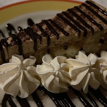 Edgar's - a slice of cake with whipped cream and chocolate sauce - American Near Me - Geneva, New York Edgar's - a slice of cake with whipped cream and chocolate sauce - American Near Me - Geneva, New York