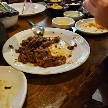 Korean BBQ House - Spicy beef after being cooked on the hot plate. Side dishes in the back. - Korean Near Me - Orange Park, Florida Korean BBQ House - Spicy beef after being cooked on the hot plate. Side dishes in the back. - Korean Near Me - Orange Park, Florida