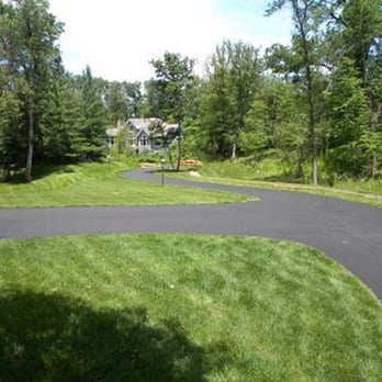 ABC Asphalt - a paved driveway in a wooded area - General Contractors Near Me