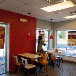 KFC - Cashier pulling down the sign for the promo she wouldn't honor. No straight talk on pricing at the KFC.