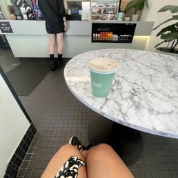 a woman sitting at a table with a cup of coffee a woman sitting at a table with a cup of coffee