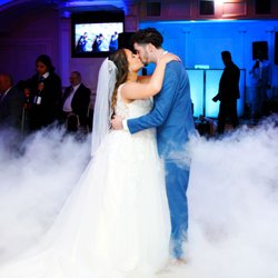 Storm Photographers - Bride and Groom kiss while a cloud of smoke rolls in behind them during their first dance