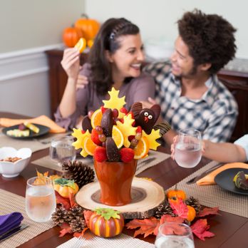 Edible Arrangements - Bunker Hill - a man and woman sitting at a table with a thanksgiving centerpiece - Gift Shops Near Me - Houston, Texas Edible Arrangements - Bunker Hill - a man and woman sitting at a table with a thanksgiving centerpiece - Gift Shops Near Me - Houston, Texas