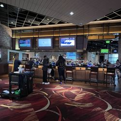 Osage Casino Hotel - Tulsa - Thunder bar tv selection/ behind the bar is the restaurant area with a stage.