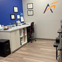 Airrosti - An interior view of the recovery room at Airrosti Brownsville. Weights, lacrosse balls, and resistance bands are visible in the background.