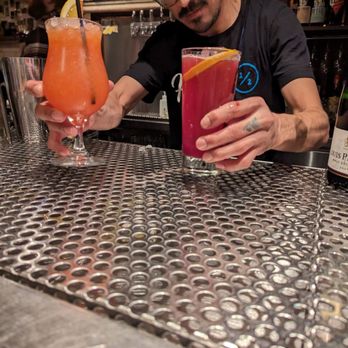 Half Step - a man at a bar with two cocktails - Cocktail Bars Near Me - Austin, Texas