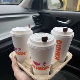 three cups of coffee on a tray in a car three cups of coffee on a tray in a car