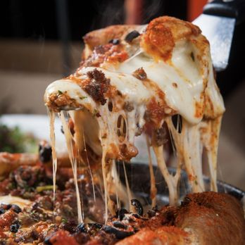 Chicago Deep Dish Pizza - a slice being lifted by a spatula - Pizza Near Me - Arlington, Texas