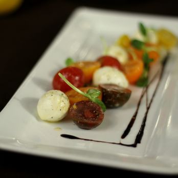 Bella Bella - a plate of food with tomatoes and mozzarella - Italian Near Me - Tallahassee, Florida