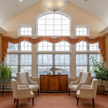 Saint Therese at St. Mary of the Woods - Residents gather in the light-filled sitting room, with its vaulted ceiling and arched window. - Retirement Homes Near Me - Avon, Ohio Saint Therese at St. Mary of the Woods - Residents gather in the light-filled sitting room, with its vaulted ceiling and arched window. - Retirement Homes Near Me - Avon, Ohio
