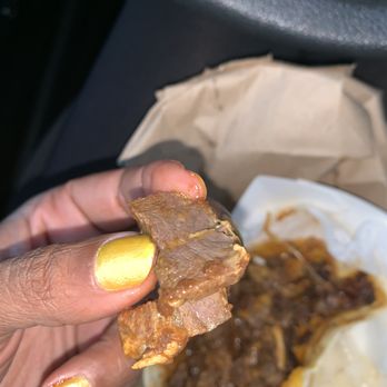 Jerk Flavors Restaurant & Lounge - a hand holding a piece of food - Caribbean Near Me - Markham, Illinois