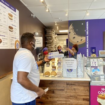 Insomnia Cookies - a man standing in front of a counter - Desserts Near Me - Memphis, Tennessee