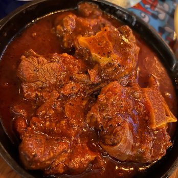 La Casa - a pan of beef stew with a glass of water in the background - Cuban Near Me - Hoboken, New Jersey La Casa - a pan of beef stew with a glass of water in the background - Cuban Near Me - Hoboken, New Jersey