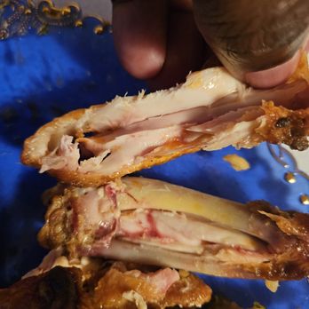 Smokin Wings - a person holding a piece of meat - Chicken Wings Near Me - Spartanburg, South Carolina Smokin Wings - a person holding a piece of meat - Chicken Wings Near Me - Spartanburg, South Carolina