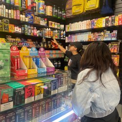 Always Lit Smoke Shop - Employee helping shopper