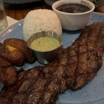 Padrino’s Cuban Restaurant - Churrasco (10 oz) with Sweet Plantains, black beans, rice and chimichurri sauce - Cuban Near Me - Dania Beach, Florida Padrino’s Cuban Restaurant - Churrasco (10 oz) with Sweet Plantains, black beans, rice and chimichurri sauce - Cuban Near Me - Dania Beach, Florida