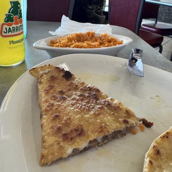 Las Parrillas Mexican Grill - The Carne Asada Quesadilla with a corn tortilla. In the background is a Pineapple Jarritos and the side of rice - Mexican Near Me - Mundelein, Illinois Las Parrillas Mexican Grill - The Carne Asada Quesadilla with a corn tortilla. In the background is a Pineapple Jarritos and the side of rice - Mexican Near Me - Mundelein, Illinois