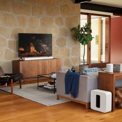 Austin Home Entertainment - Sonos Arc, Sonos One SL surrounds, and Sonos Sub in white with Samsung TV controlled from one remote or voice.