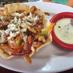 Chicken fajita taco salad with side of beans and cheese. Chicken fajita taco salad with side of beans and cheese.