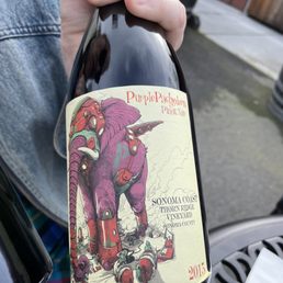 a hand holding a bottle of wine