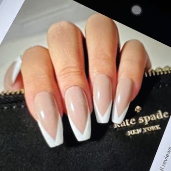 Encore Nails&Spa - This is what I asked for. - The image shows a close-up of a hand with well-groomed nails painted in a French manicure style, featuring natural pink bases and white tips. The hand is holding a black Kate Spade pouch with gold lettering that reads 'kate spade NEW YORK.' The background appears to be a neutral surface, and part of a device or paper is visible in the top left corner. - Nail Salons Near Me - Coventry, Rhode Island