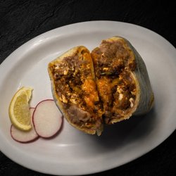 A hearty breakfast burrito filled with beans, scrambled eggs, chorizo, and melted cheese, wrapped in a 13" flour tortilla.