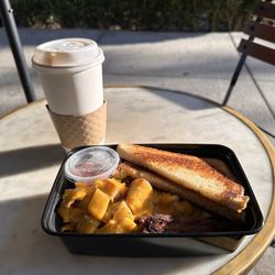 Franklin’s - Breakfast bowl with, eggs, grits, potatoes, and bacon. Along with a caramel macchiato.