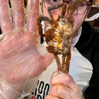 Hook & Reel Cajun Seafood & Bar - a man holding a crab - Cajun/Creole Near Me - Orange, Connecticut