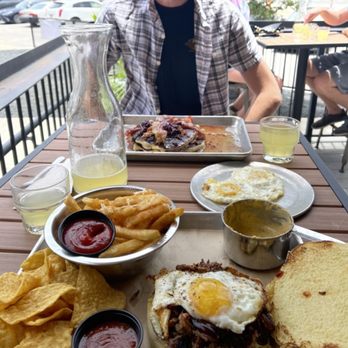 Industry - porky pancakes, brisket breakfast burger, a pineapple mimosa carafe, and side of queso and parmesan fries - New American Near Me - San Marcos, Texas Industry - porky pancakes, brisket breakfast burger, a pineapple mimosa carafe, and side of queso and parmesan fries - New American Near Me - San Marcos, Texas