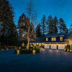 Hardscape lighting to highlight bushes and trees in driveway.