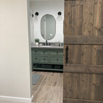 Carmel Construction - a view of a bathroom through a barn door - General Contractors Near Me