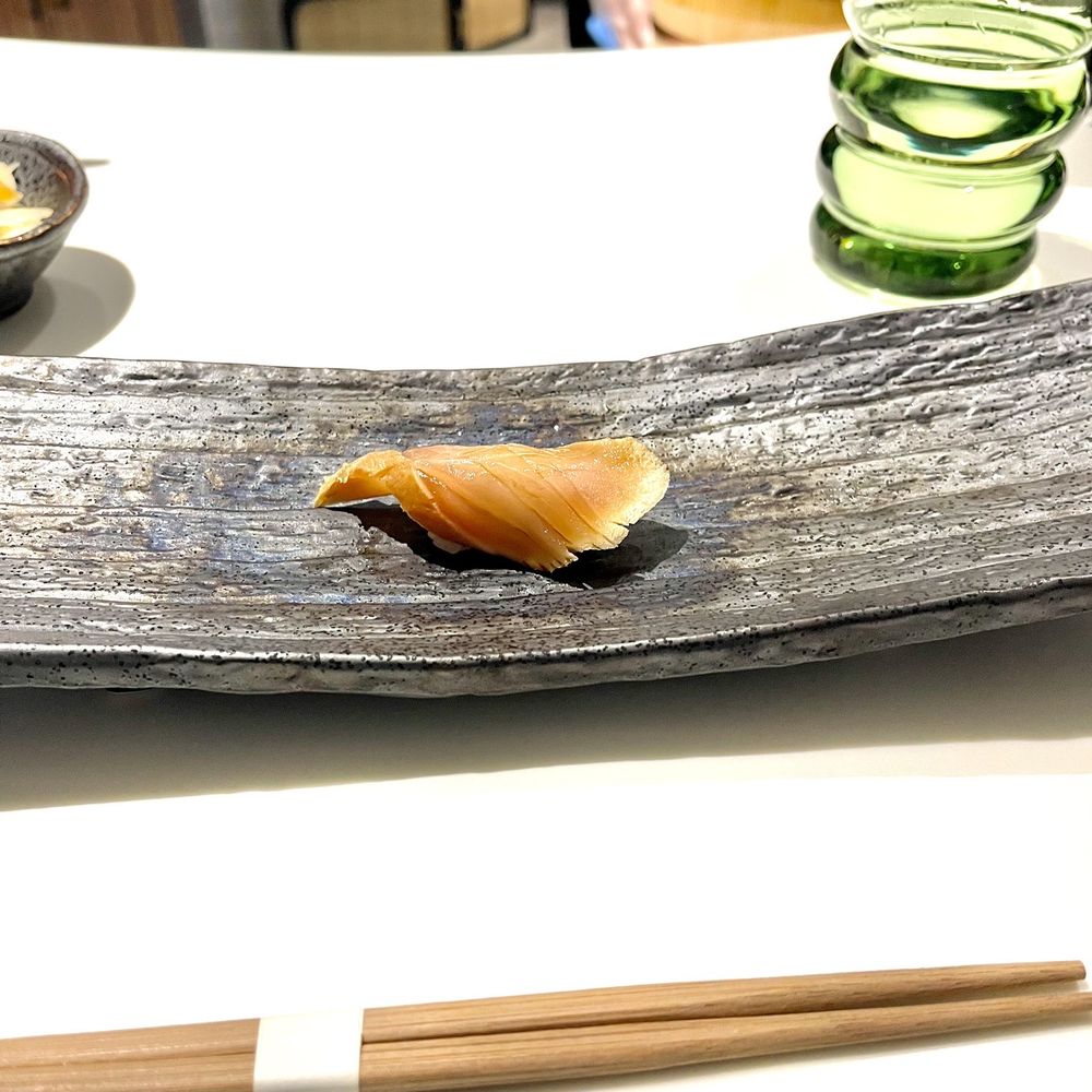 Hōseki - a piece of sushi on a plate with chopsticks - Sushi Bars Near Me - New York, New York