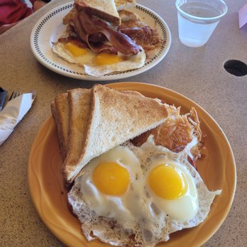 Wright Bros Cafe & Grille - #1 with sunny side eggs. Mine has portuguese sausage. His has ham aka bacon. Was expecting ham sliced but bacon is always welcomed. - Cafes Near Me - Honolulu, Hawaii
