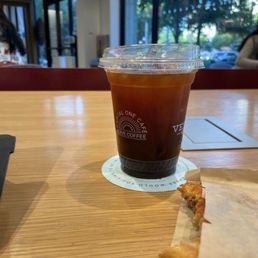 An iced americano with a round puff pastry. An iced americano with a round puff pastry.