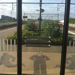 Station Breukelen - Gedicht op deur wachtruimte en man op de grond voor wachtruimte, perron