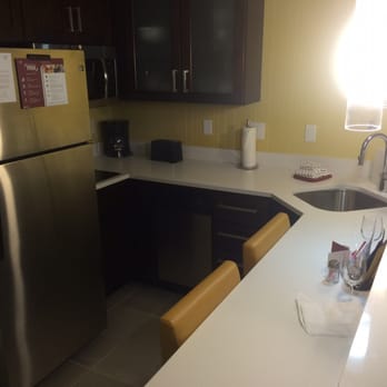 Residence Inn by Marriott Harlingen - Nice kitchenette with a regular sized fridge, two oven burners, dishwasher, microwave, sink, and bar chair. - Hotels Near Me - Harlingen, Texas Residence Inn by Marriott Harlingen - Nice kitchenette with a regular sized fridge, two oven burners, dishwasher, microwave, sink, and bar chair. - Hotels Near Me - Harlingen, Texas